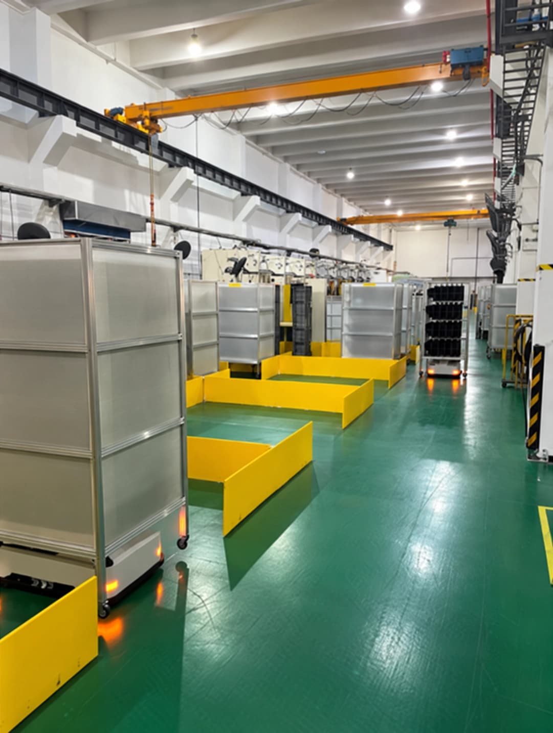 Lifting AMRs moving enclosed racks along a one-way lane beside marked floor positions