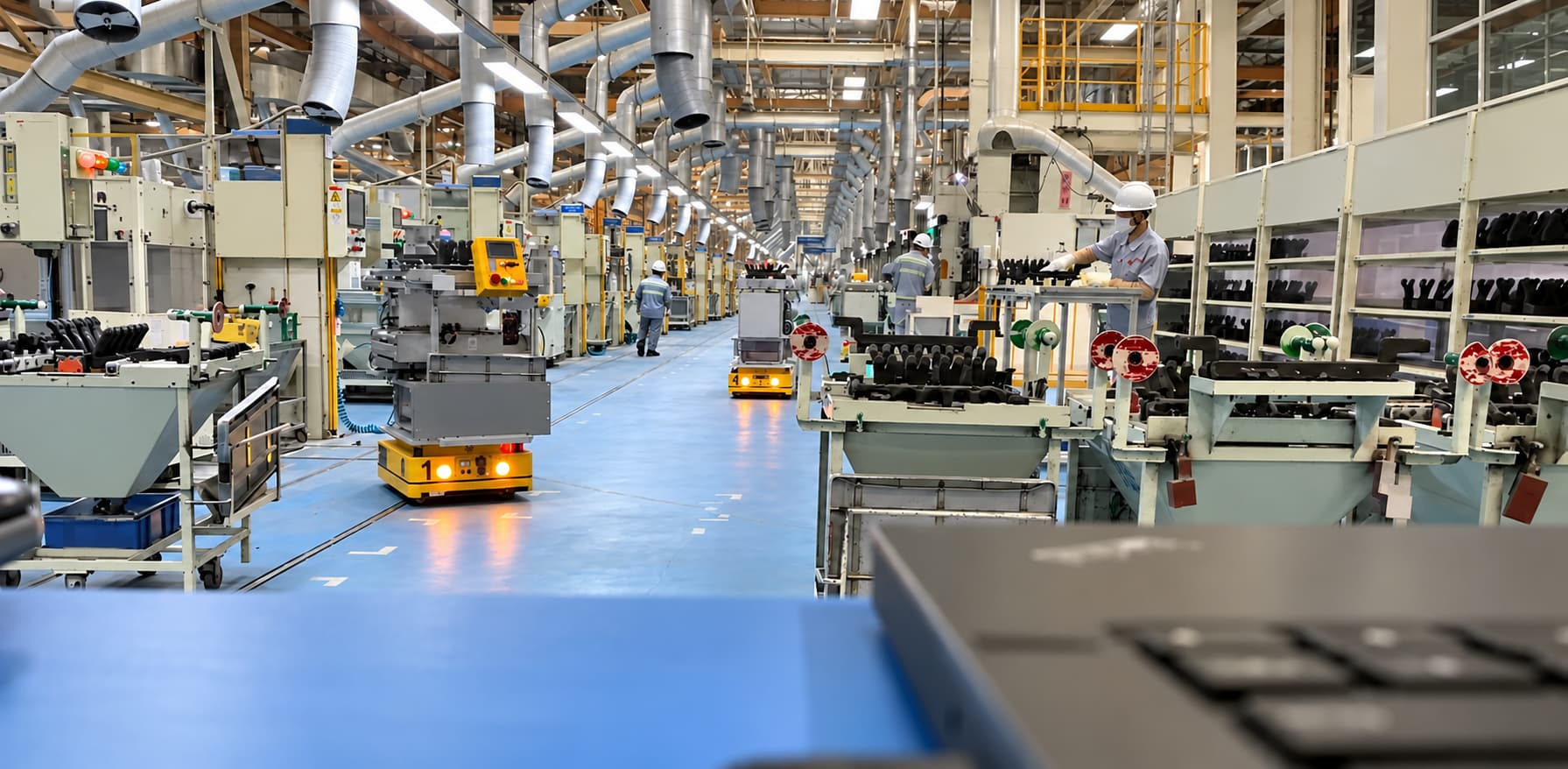 AMRs carrying parts racks along a production-line aisle